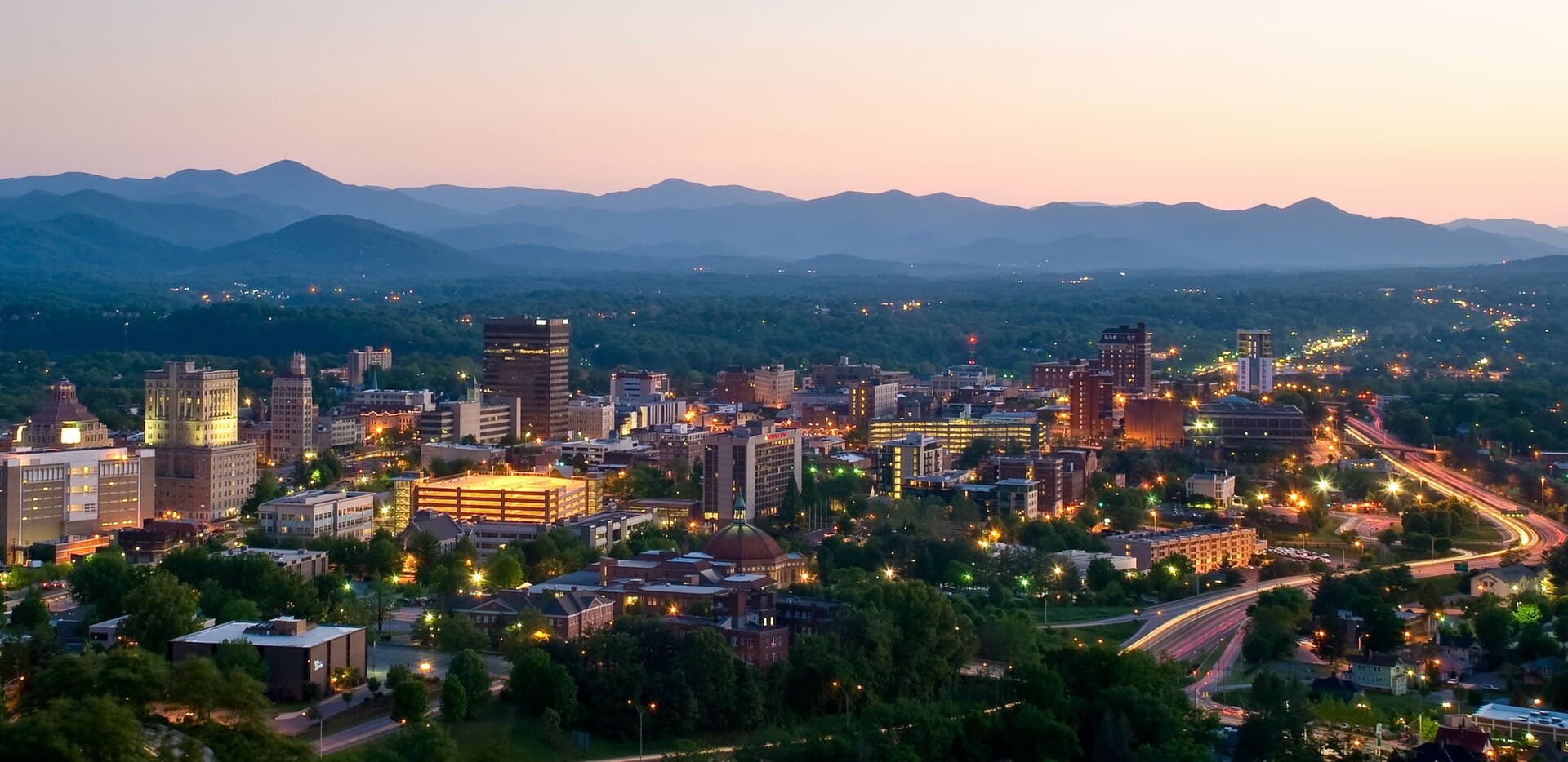 Downtown Asheville at dusk with the Blue Ridge behind — North Carolina